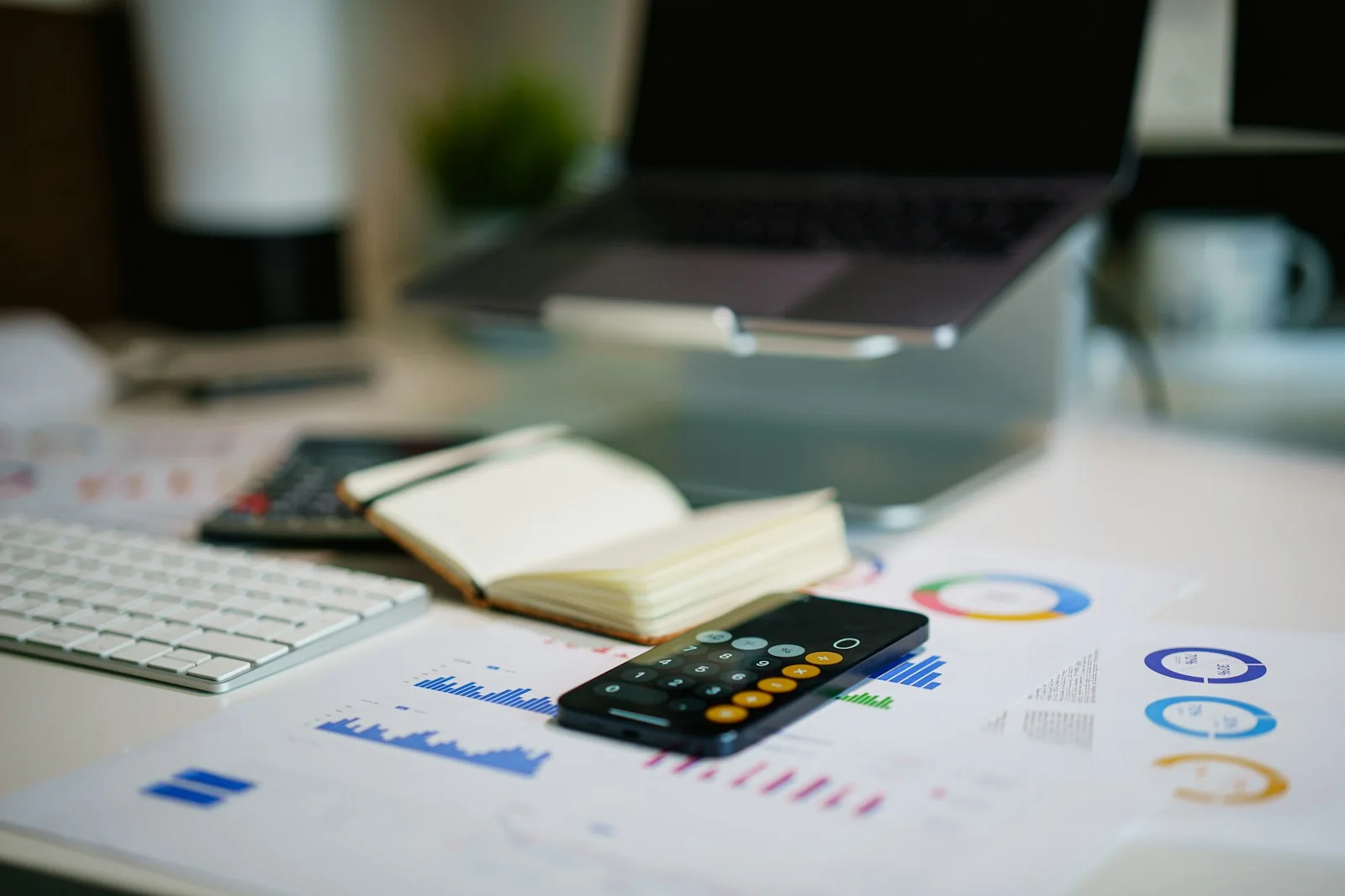 Printed charts, calculator and notebook on a desk