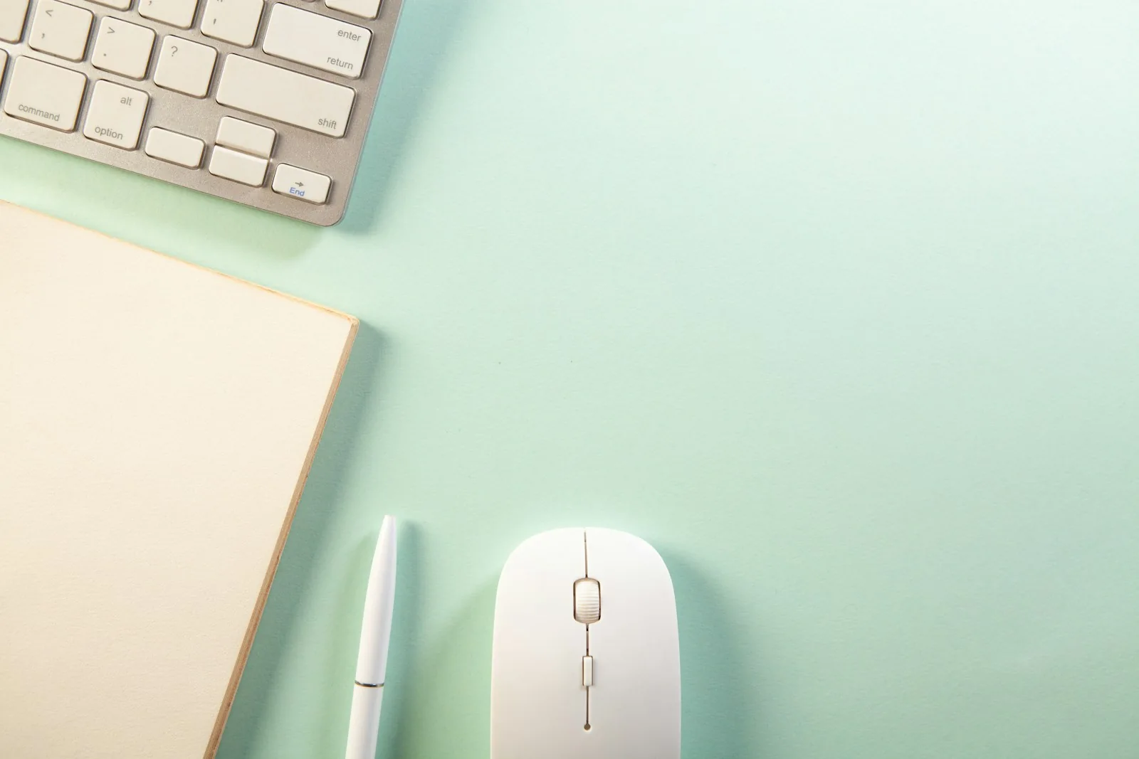 Keyboard, notebook, pen and mouse on a desk
